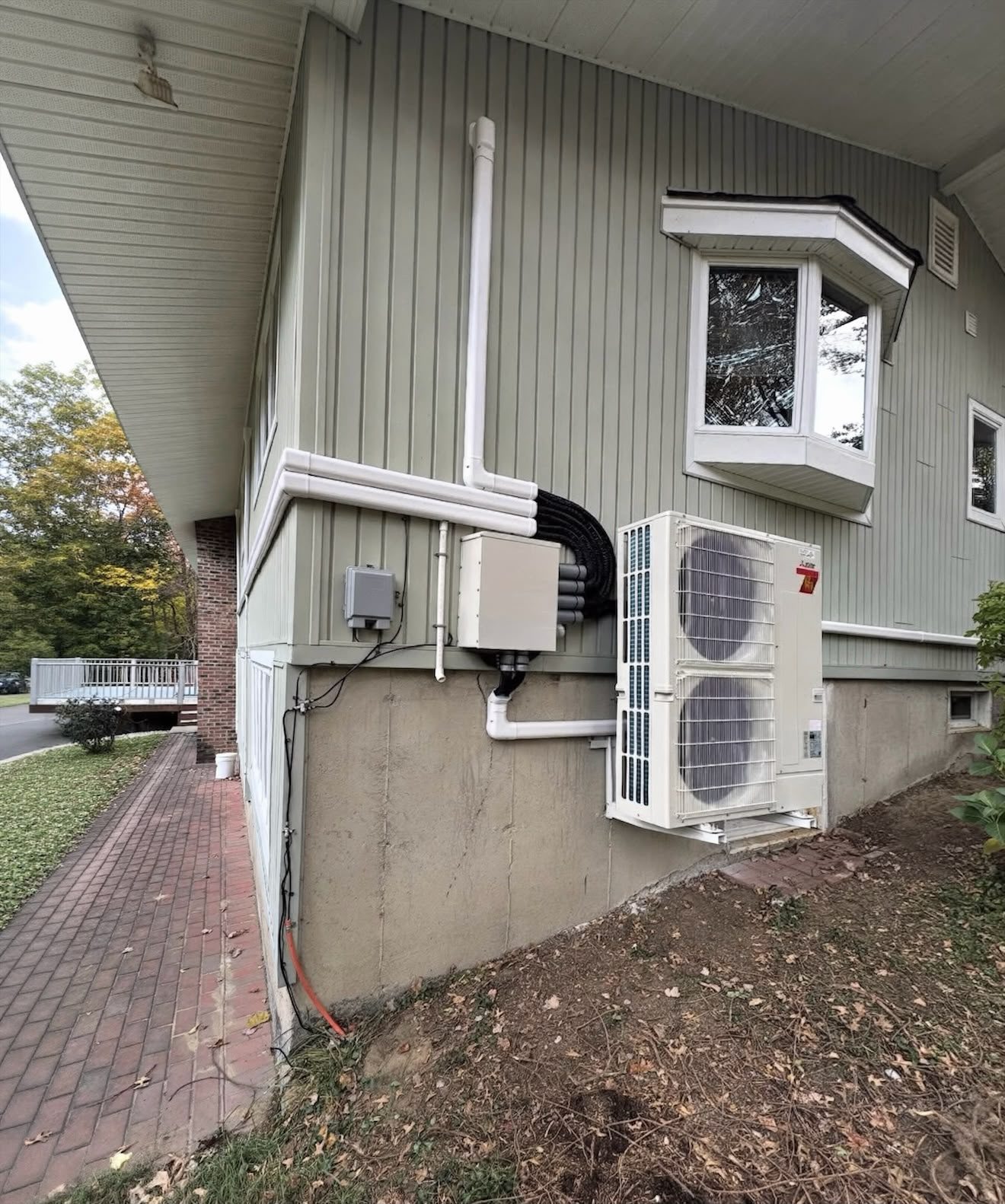 Mitsubishi outdoor heat pump installation with neatly routed line sets by EcoAir MJ Corp